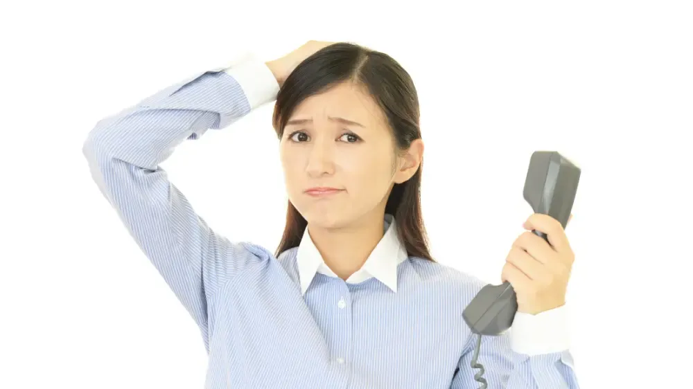 電話対応に悩む女性のイメージ